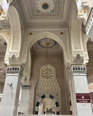 Carved stone arches and decorated ceiling inside Masjid an-Nabawi.